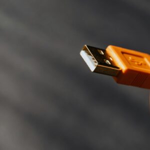 Detailed shot capturing an orange USB cable connector on a contrasting background.